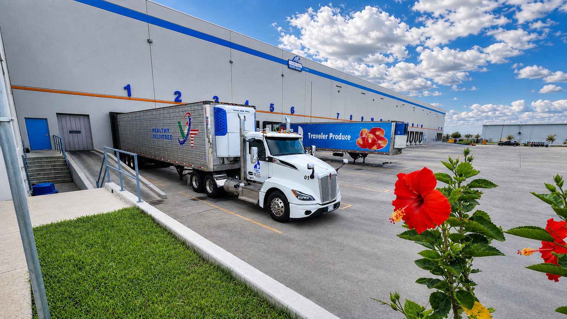 Refrigerated trucks and branded produce trailer positioned at the Traveler Produce loading area