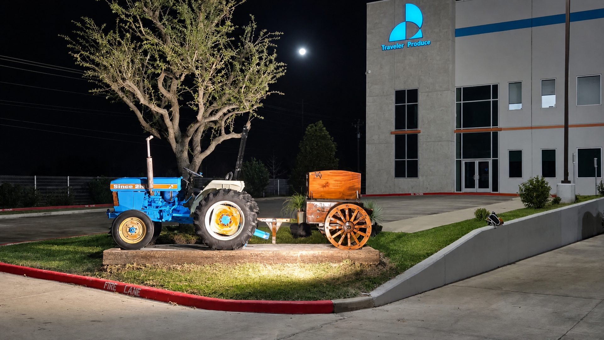 Traveler Produce facility and illuminated heritage tractor at night